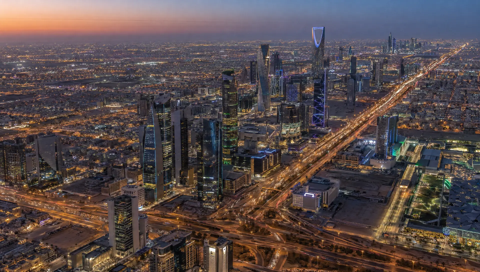 Aerial view of Riyadh at dusk — the Kingdom Centre and highway light trails above the city where Maingate keeps its on-the-ground team.